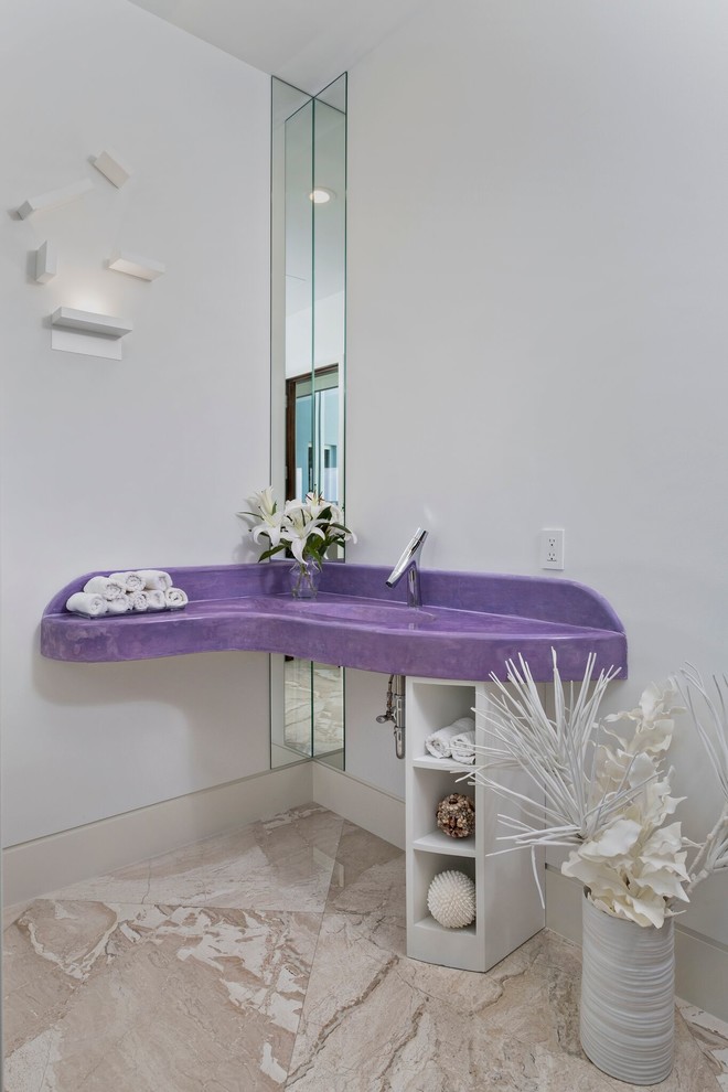マイアミにあるトロピカルスタイルのおしゃれなトイレ・洗面所 (オープンシェルフ、白いキャビネット、白い壁、一体型シンク、ベージュの床、紫の洗面カウンター) の写真