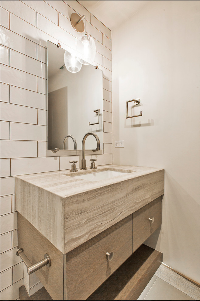 Idee per un bagno di servizio country di medie dimensioni con pareti bianche, pavimento grigio, ante lisce, piastrelle bianche, lavabo sottopiano, top in travertino e top beige