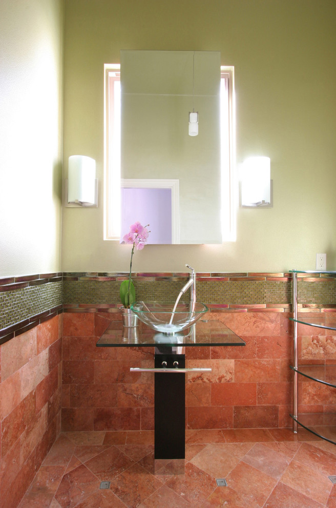 Inspiration för mellanstora moderna toaletter, med skåp i mörkt trä, grön kakel, rosa kakel, glaskakel, gröna väggar, travertin golv, ett fristående handfat och bänkskiva i glas