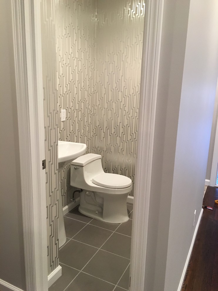 Foto di un piccolo bagno di servizio minimal con WC monopezzo, piastrelle grigie, piastrelle in gres porcellanato, pareti grigie, pavimento in gres porcellanato e lavabo a colonna