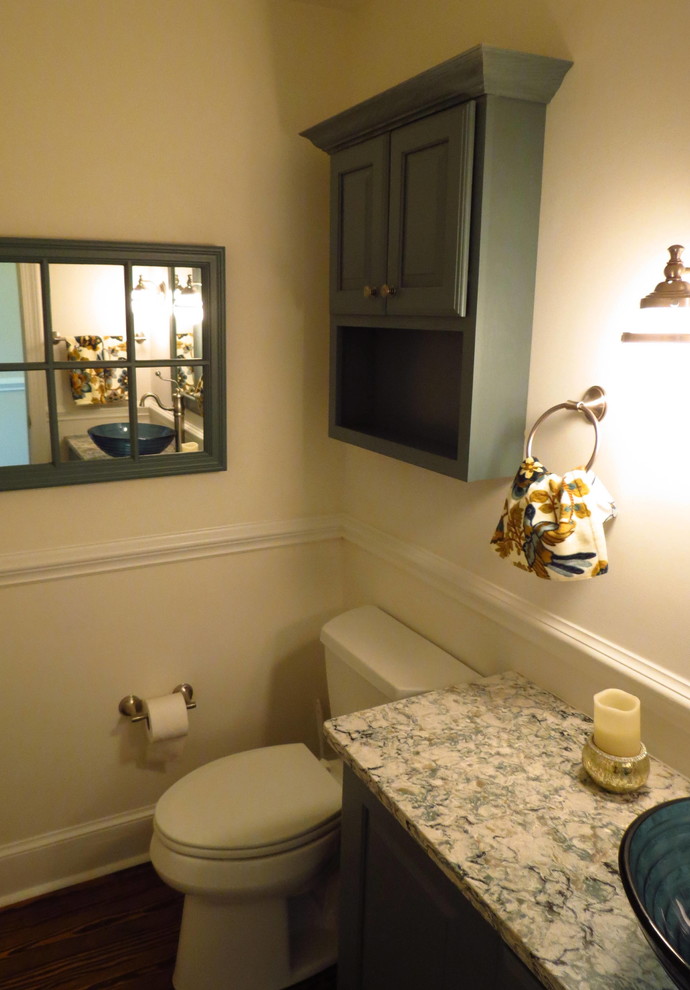 Inredning av ett lantligt litet toalett, med luckor med upphöjd panel, en toalettstol med separat cisternkåpa, beige väggar, mellanmörkt trägolv, ett fristående handfat och marmorbänkskiva