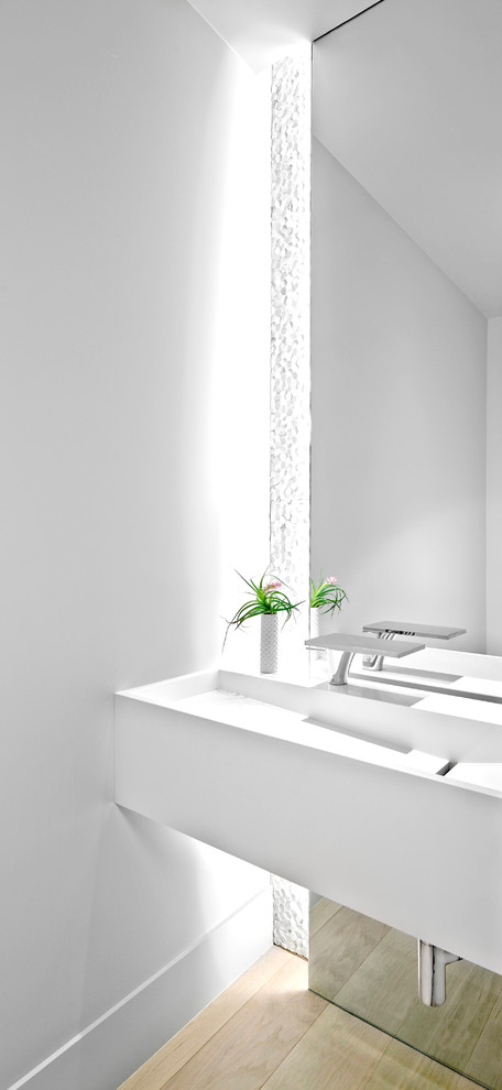 Cette photo montre un WC et toilettes tendance de taille moyenne avec un mur blanc et parquet clair.