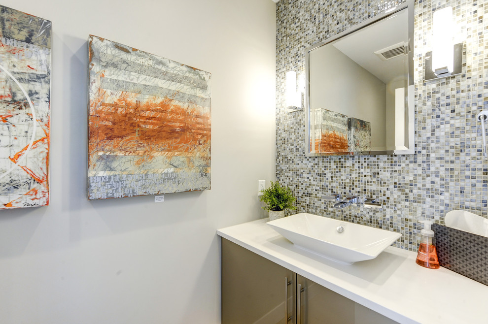Contemporary cloakroom in Denver with flat-panel cabinets, beige cabinets, multi-coloured tiles, glass tiles, grey walls, light hardwood flooring and a vessel sink.