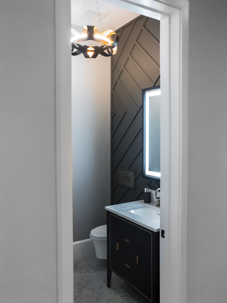 Photo of a small contemporary cloakroom in Toronto with flat-panel cabinets, blue cabinets, a wall mounted toilet, black walls, marble flooring, a submerged sink, engineered stone worktops, multi-coloured floors, white worktops, a freestanding vanity unit and panelled walls.