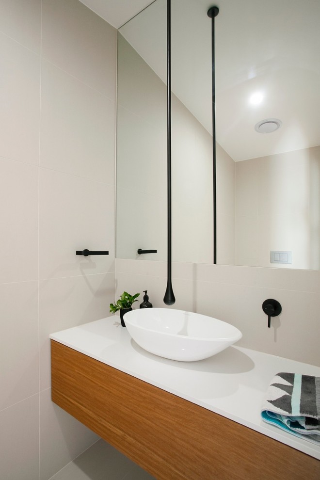 Moderne Gästetoilette mit flächenbündigen Schrankfronten, hellbraunen Holzschränken und Aufsatzwaschbecken in Sunshine Coast