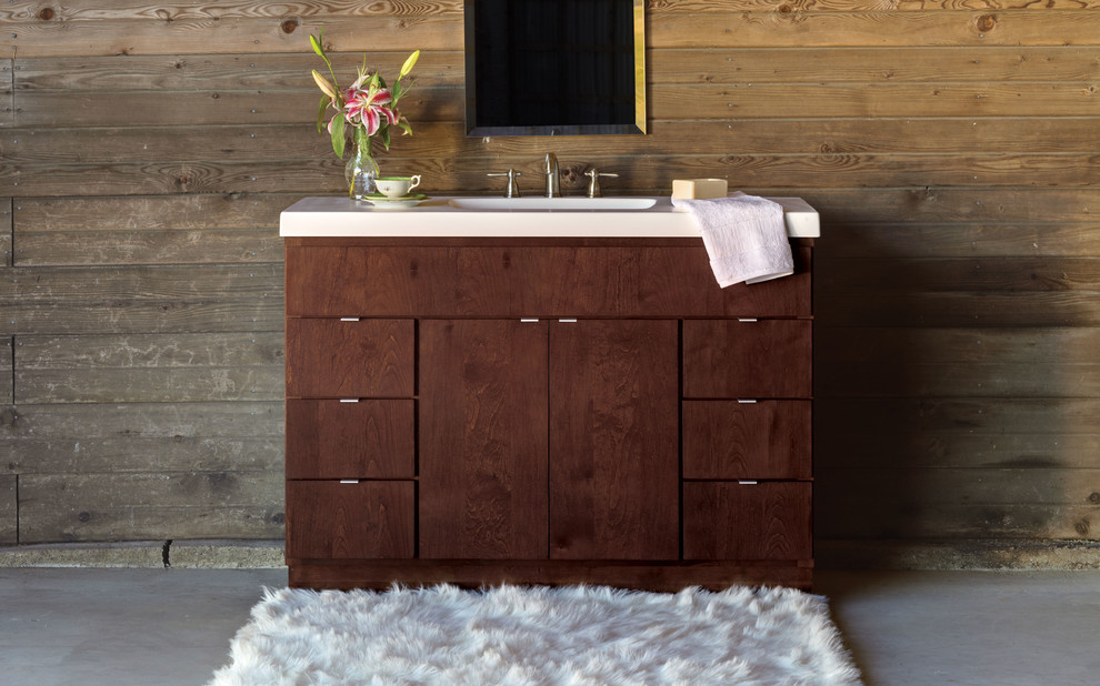 Modernes Badezimmer mit Einbauwaschbecken, flächenbündigen Schrankfronten, dunklen Holzschränken, Mineralwerkstoff-Waschtisch, brauner Wandfarbe und Betonboden in Raleigh