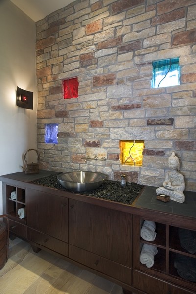 Ispirazione per un ampio bagno di servizio contemporaneo con ante in legno bruno, pareti beige, lavabo a bacinella, parquet chiaro e ante lisce