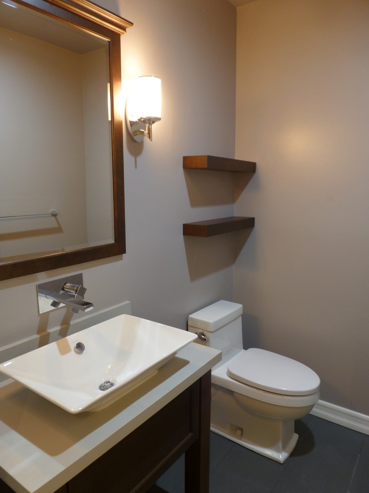 Réalisation d'un petit WC et toilettes design en bois foncé avec une vasque, un plan de toilette en quartz modifié, WC à poser, un carrelage gris, un mur gris et un sol en carrelage de porcelaine.