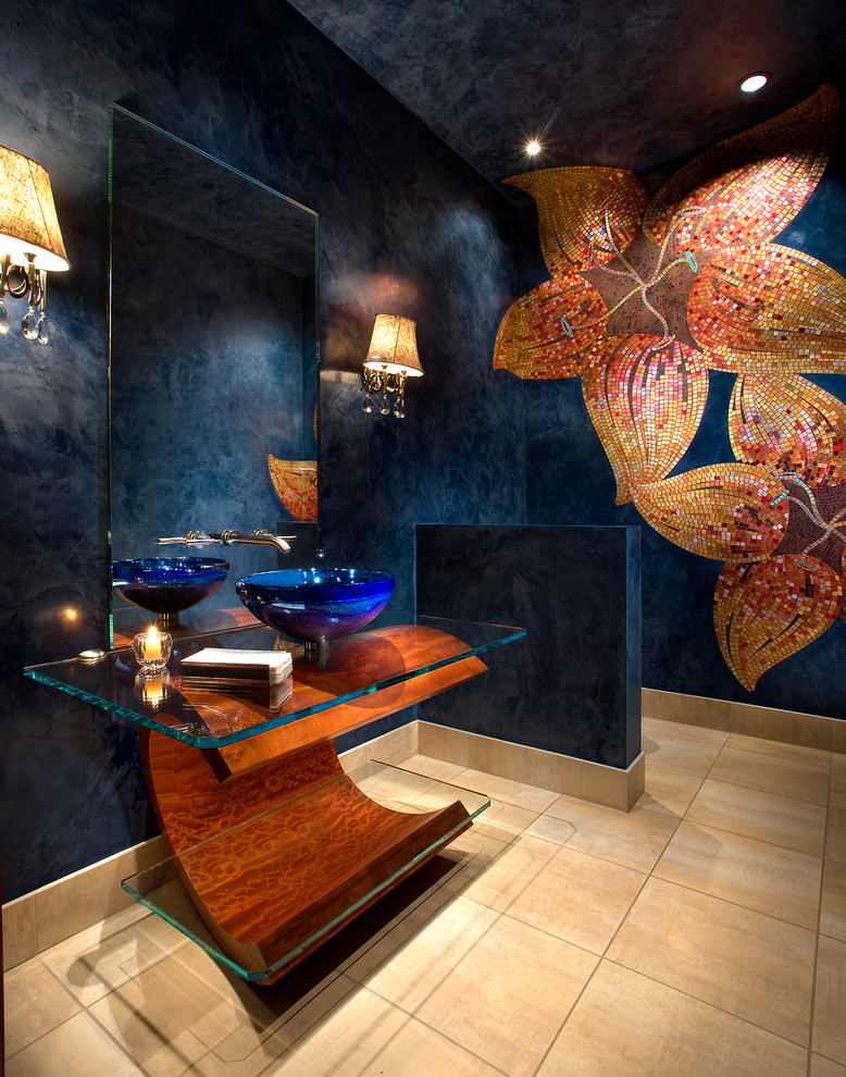 На фото: туалет в современном стиле с плиткой мозаикой, синими стенами, настольной раковиной, стеклянной столешницей, бежевым полом и бежевой плиткой