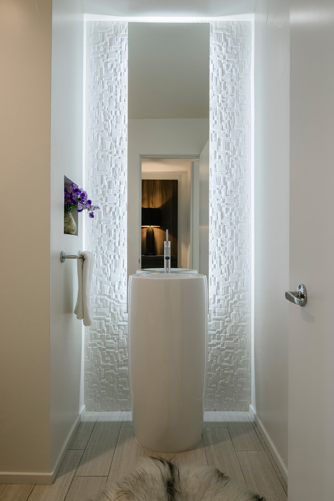 ロサンゼルスにある高級な小さなコンテンポラリースタイルのおしゃれなトイレ・洗面所 (一体型トイレ	、白いタイル、磁器タイル、白い壁、磁器タイルの床、ペデスタルシンク、白い床) の写真