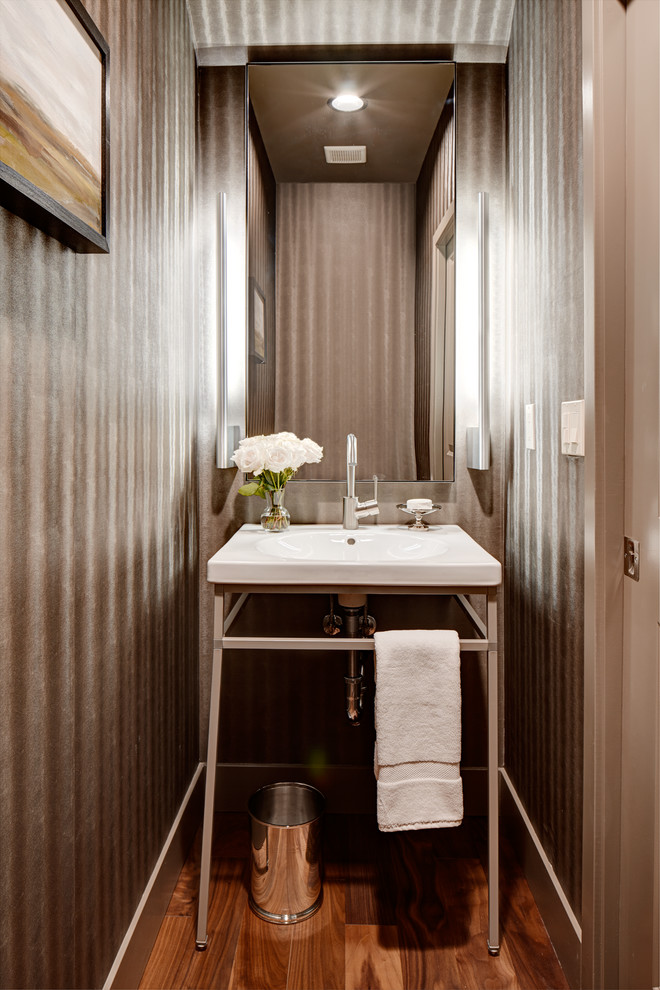 Immagine di un bagno di servizio contemporaneo con lavabo a consolle, pareti grigie e pavimento in legno massello medio