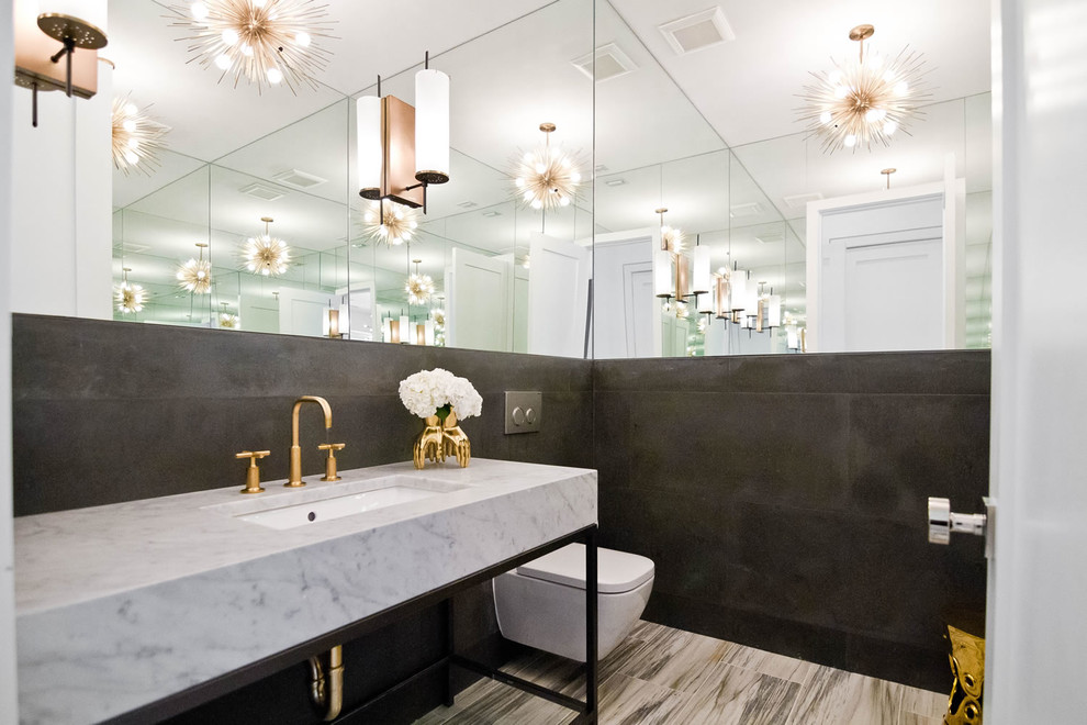 Immagine di un bagno di servizio contemporaneo con WC sospeso, pareti nere, lavabo sottopiano, top in marmo, pavimento beige e top grigio