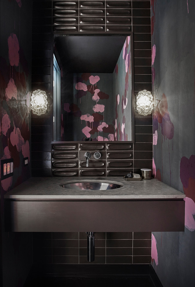 На фото: туалет в современном стиле с черной плиткой, разноцветными стенами, врезной раковиной и серой столешницей