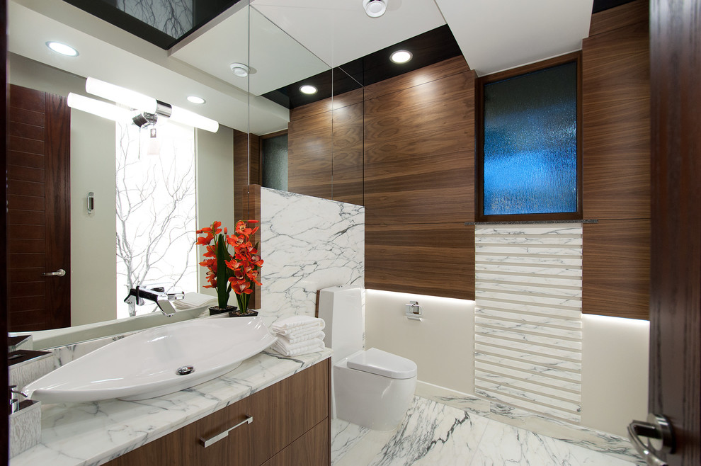 Moderne Gästetoilette mit flächenbündigen Schrankfronten, Marmor-Waschbecken/Waschtisch, Toilette mit Aufsatzspülkasten, weißen Fliesen, Aufsatzwaschbecken, dunklen Holzschränken und Marmorfliesen in Vancouver