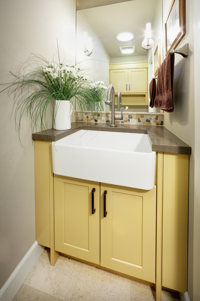 Cette photo montre un petit WC et toilettes chic avec un placard à porte shaker, des portes de placard jaunes, un carrelage beige, un carrelage marron, un carrelage gris, un mur beige, carreaux de ciment au sol, un plan de toilette en granite et une plaque de galets.