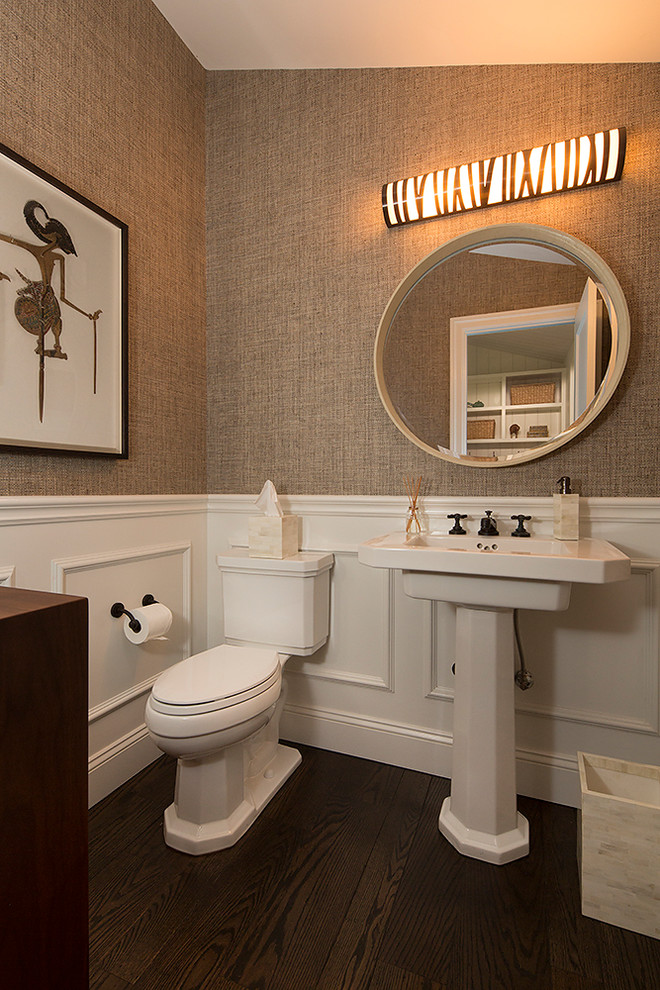 Inspiration for a mid-sized contemporary dark wood floor and brown floor powder room remodel in San Francisco with flat-panel cabinets, dark wood cabinets, a two-piece toilet, beige walls, a pedestal sink, solid surface countertops and white countertops