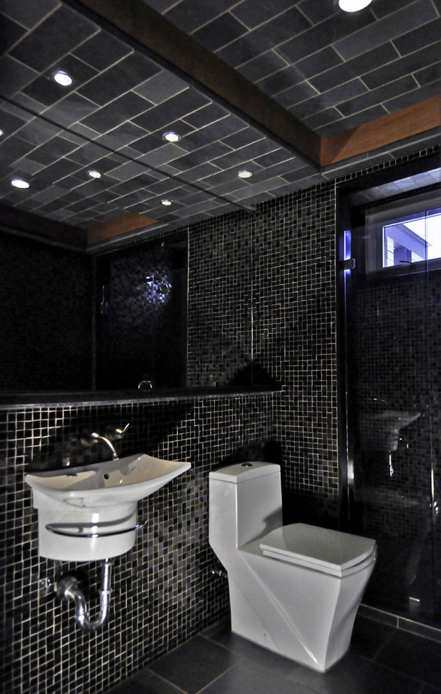 На фото: туалет среднего размера в современном стиле с черной плиткой, подвесной раковиной, унитазом-моноблоком, стеклянной плиткой, открытыми фасадами, черными стенами, полом из керамической плитки, столешницей из искусственного камня и черным полом с