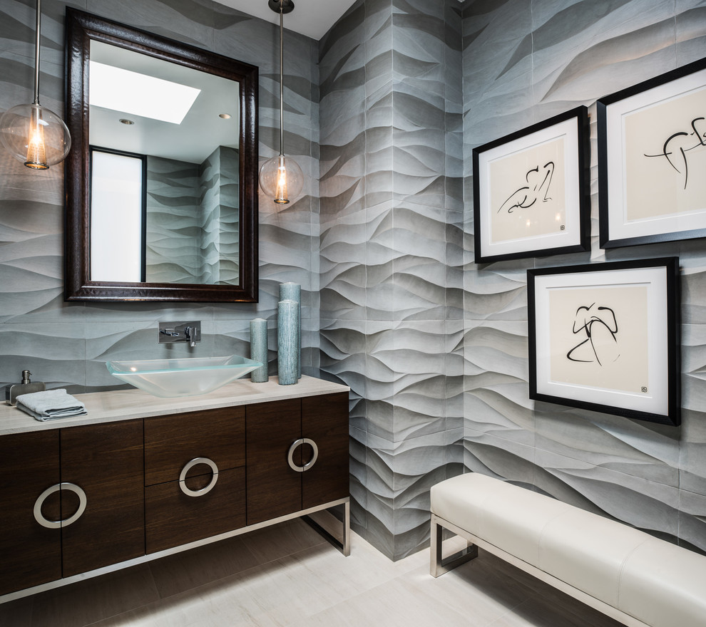 На фото: туалет в современном стиле с настольной раковиной, плоскими фасадами, темными деревянными фасадами, серой плиткой и серыми стенами