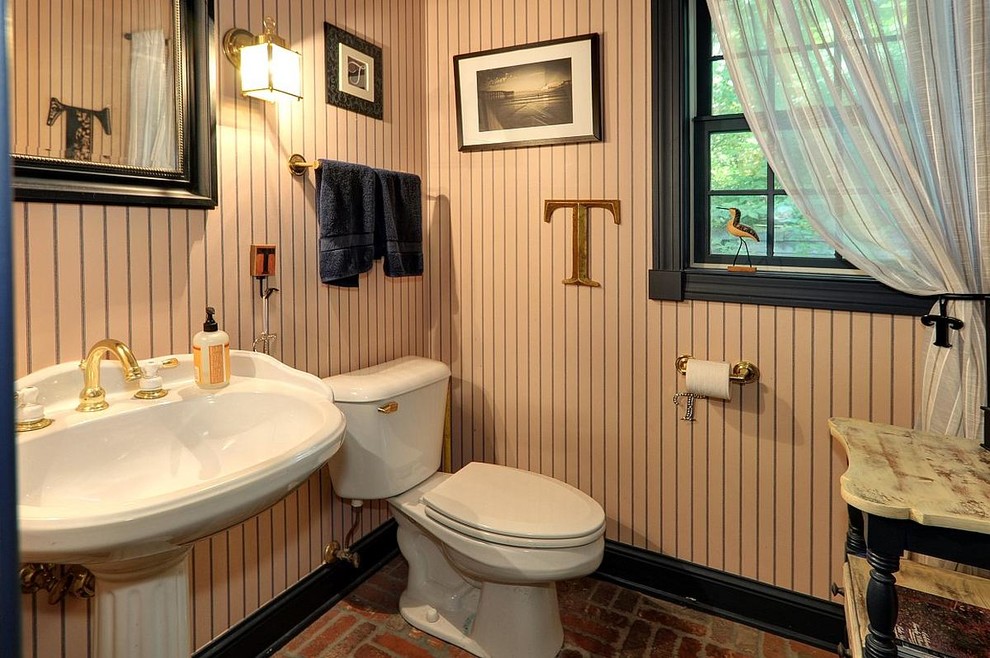 Inredning av ett rustikt mellanstort toalett, med ett piedestal handfat, en toalettstol med separat cisternkåpa, flerfärgade väggar och tegelgolv