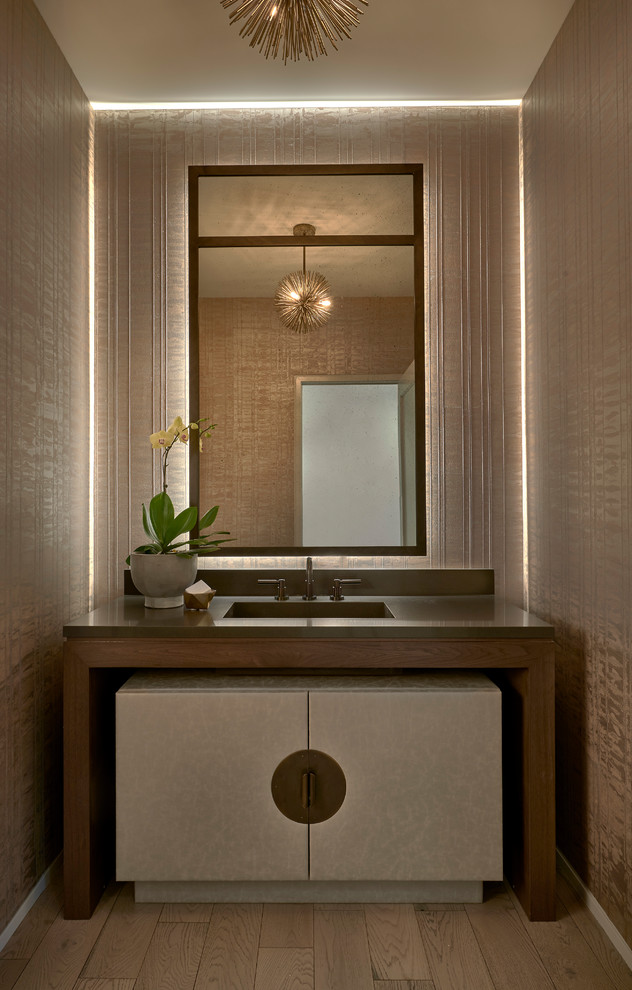Diseño de aseo contemporáneo con paredes beige, suelo de madera en tonos medios, lavabo integrado, suelo marrón y encimeras grises