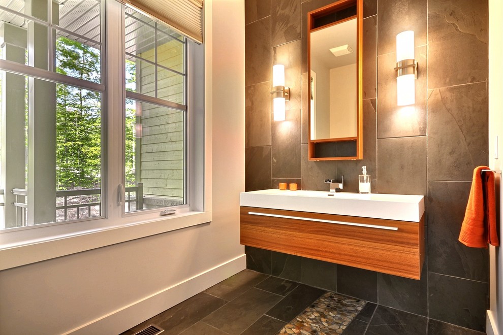 Moderne Gästetoilette mit hellbraunen Holzschränken, braunen Fliesen, Wandwaschbecken und Schieferfliesen in Montreal