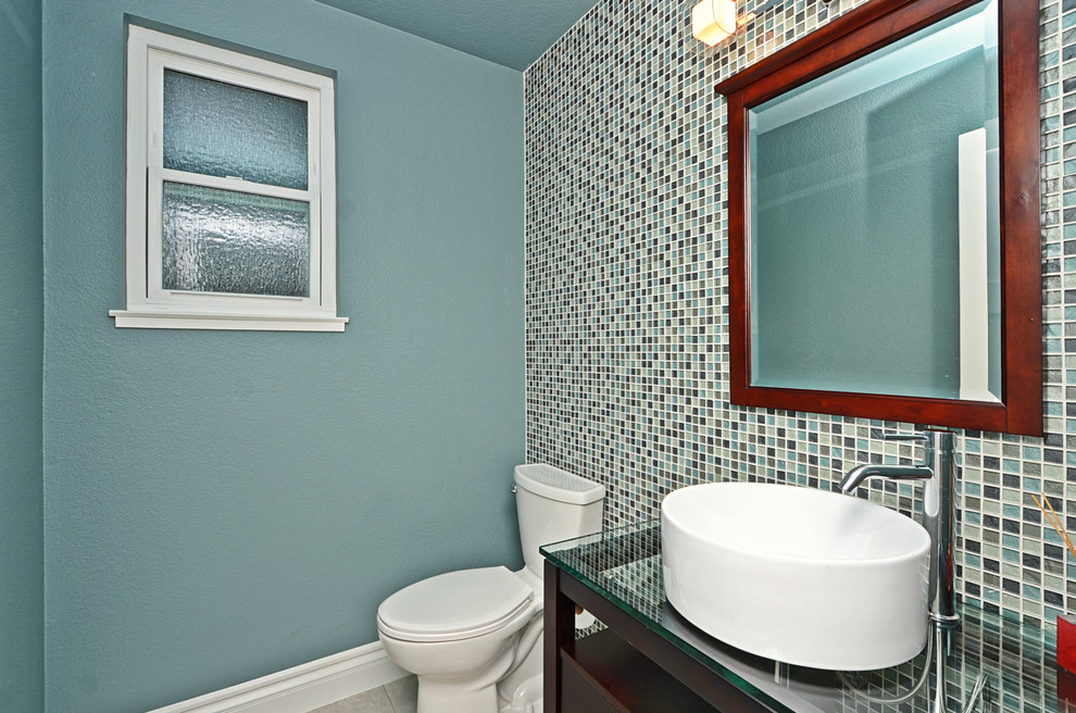Идея дизайна: маленький туалет в современном стиле с фасадами островного типа, темными деревянными фасадами, унитазом-моноблоком, синей плиткой, зеленой плиткой, разноцветной плиткой, плиткой мозаикой, синими стенами, полом из керамической плитки, настольной раковиной, стеклянной столешницей и серым полом для на участке и в саду
