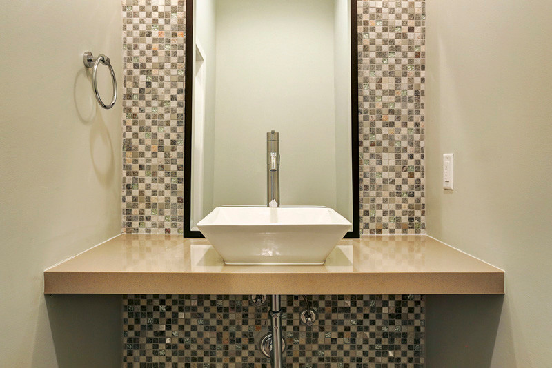 Ispirazione per un bagno di servizio minimal di medie dimensioni con WC a due pezzi, piastrelle multicolore, pareti grigie, lavabo a bacinella, piastrelle a mosaico e top in superficie solida