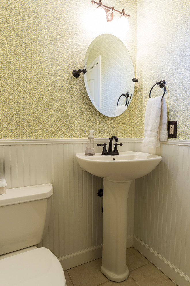 Immagine di un piccolo bagno di servizio tradizionale con WC a due pezzi, piastrelle beige, pareti multicolore, pavimento con piastrelle in ceramica e lavabo a colonna