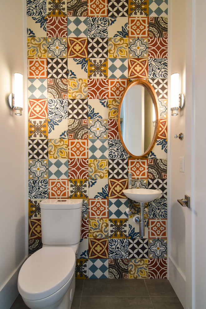Kleine Eklektische Gästetoilette mit Wandtoilette mit Spülkasten, farbigen Fliesen, Zementfliesen, bunten Wänden, Betonboden, Wandwaschbecken und braunem Boden in Charleston