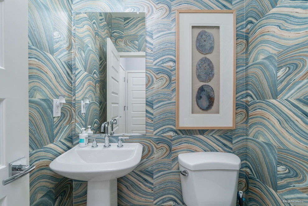 Mid-sized beach style porcelain tile and gray floor powder room photo in Phoenix with a two-piece toilet, multicolored walls and a pedestal sink