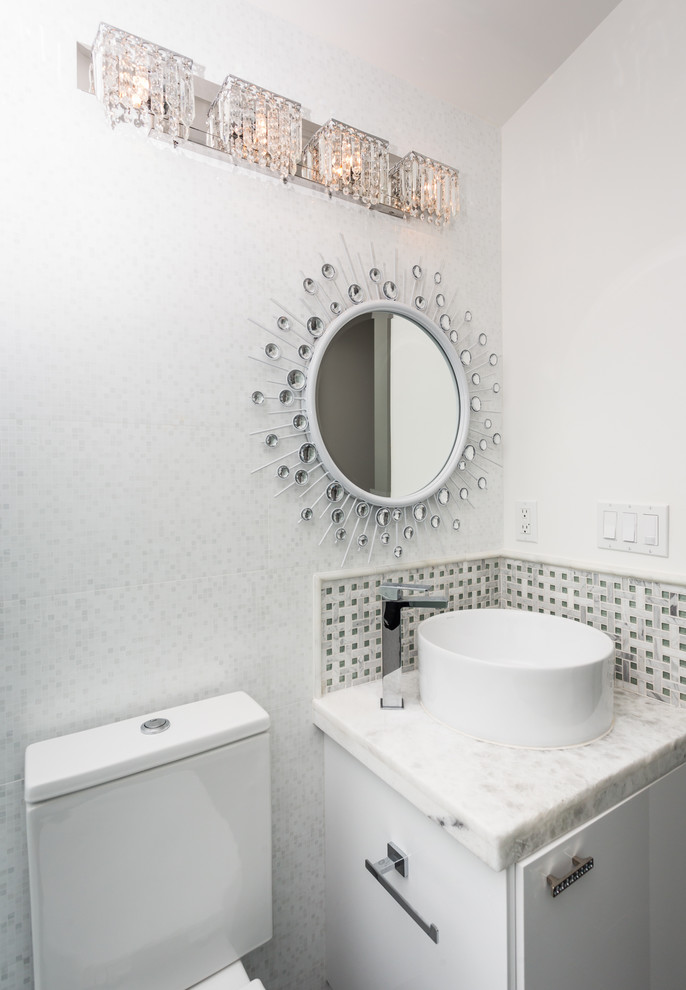 Пример оригинального дизайна: туалет в современном стиле с настольной раковиной, плоскими фасадами, белыми фасадами, белой плиткой, серой плиткой, белыми стенами и белой столешницей