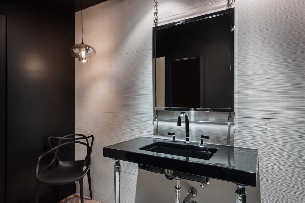 На фото: туалет в современном стиле с столешницей из искусственного кварца, унитазом-моноблоком, белой плиткой, керамогранитной плиткой, черными стенами, светлым паркетным полом, врезной раковиной и черной столешницей с