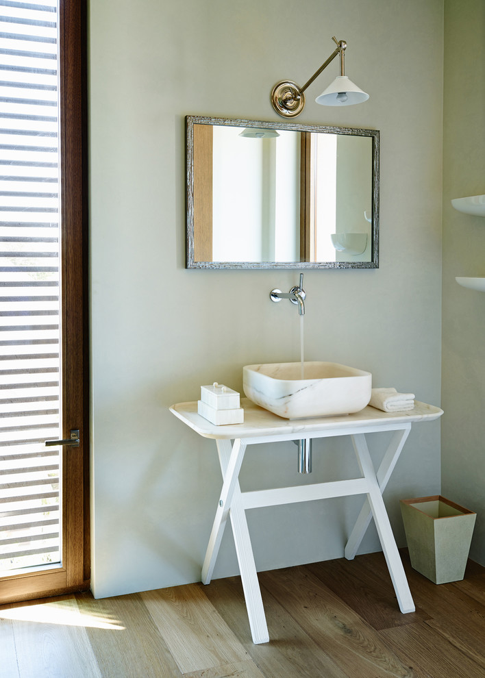 Источник вдохновения для домашнего уюта: туалет в средиземноморском стиле с настольной раковиной, зелеными стенами и паркетным полом среднего тона