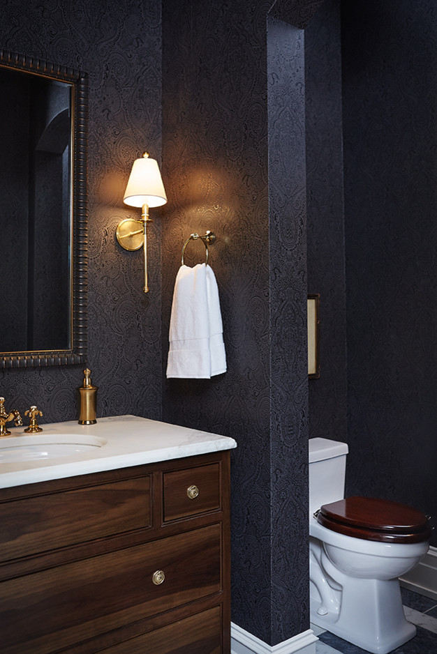 Klassisk inredning av ett mellanstort toalett, med ett undermonterad handfat, marmorbänkskiva, en toalettstol med hel cisternkåpa, svarta väggar och marmorgolv