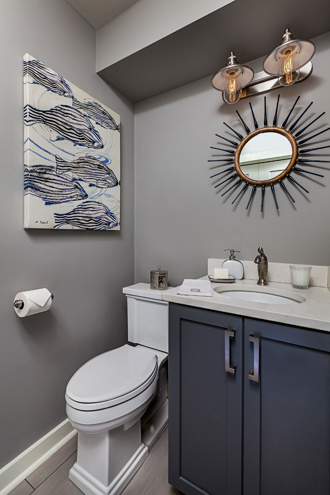 Cette image montre un petit WC et toilettes marin avec un placard à porte shaker, des portes de placard grises, WC séparés, un mur gris, un sol en carrelage de porcelaine, un lavabo encastré et un plan de toilette en quartz modifié.