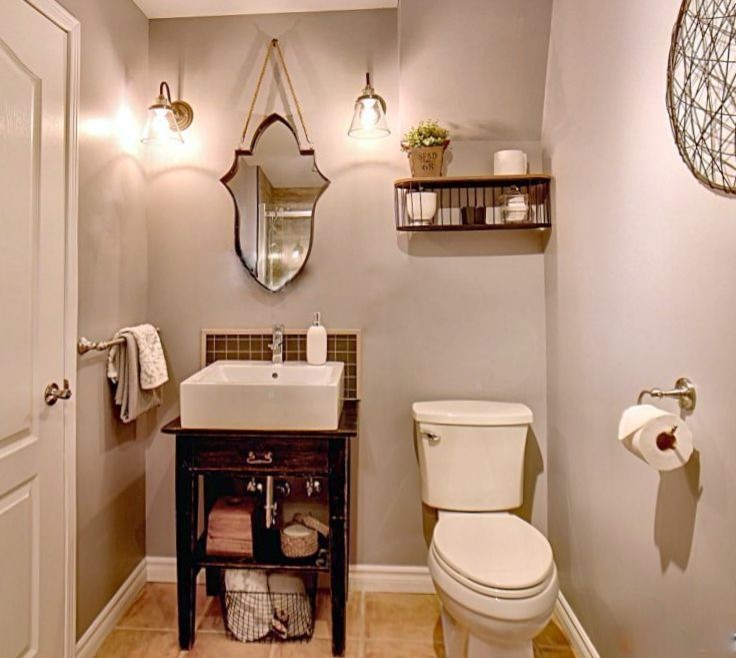 Bild på ett litet lantligt svart svart toalett, med öppna hyllor, svarta skåp, en toalettstol med separat cisternkåpa, svart kakel, keramikplattor, grå väggar, klinkergolv i keramik, ett väggmonterat handfat, träbänkskiva och beiget golv