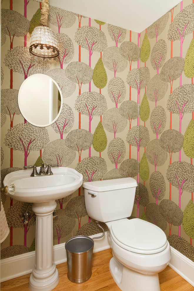 Immagine di un piccolo bagno di servizio classico con lavabo a colonna, WC a due pezzi, pavimento in legno massello medio e pareti multicolore