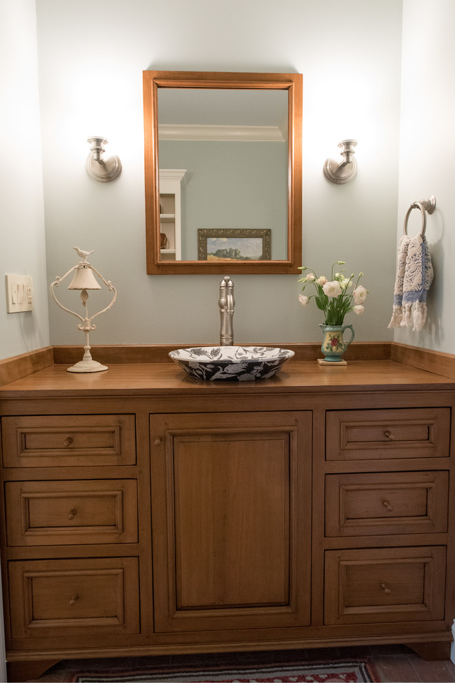 Idee per un piccolo bagno di servizio tradizionale con consolle stile comò, ante in legno scuro, pareti blu, parquet chiaro, lavabo a bacinella, top in legno, pavimento marrone e top marrone