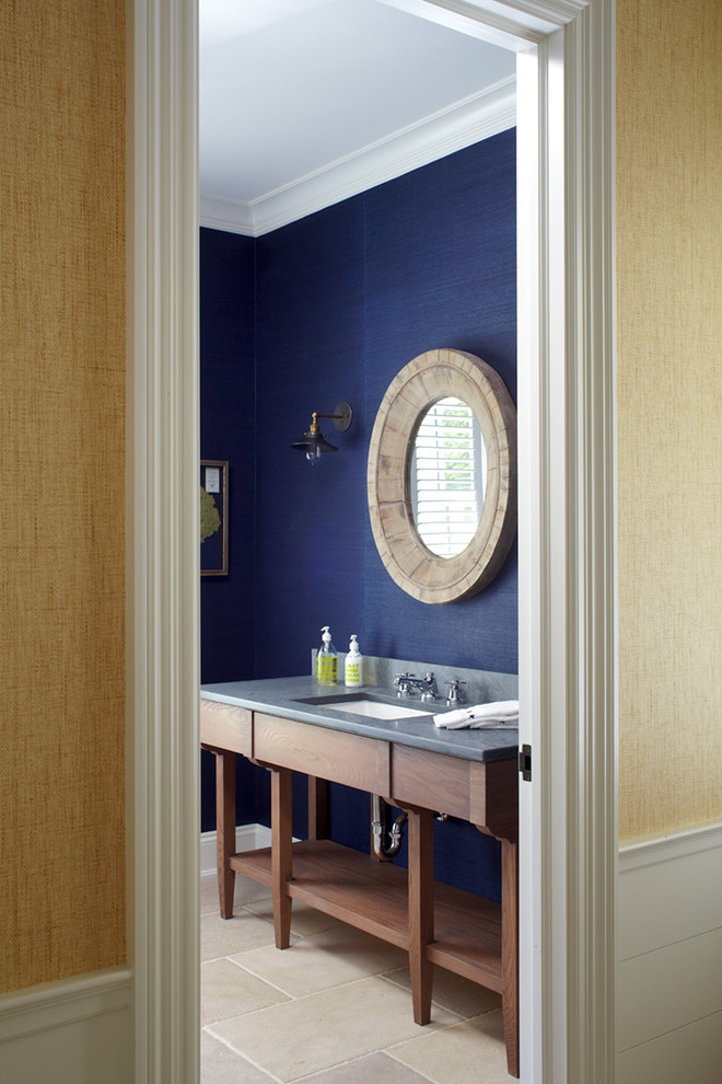 Idée de décoration pour un grand WC et toilettes marin en bois brun avec un placard en trompe-l'oeil, un carrelage beige, un mur bleu, un sol en calcaire, un lavabo encastré et un plan de toilette en marbre.