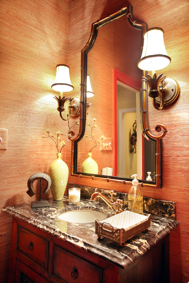ダラスにあるエクレクティックスタイルのおしゃれなトイレ・洗面所 (アンダーカウンター洗面器、赤いキャビネット、大理石の洗面台、赤い壁) の写真