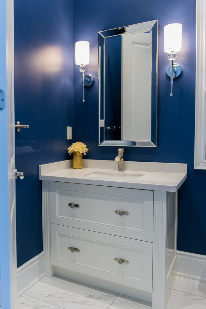 Klassische Gästetoilette mit Schrankfronten mit vertiefter Füllung, weißen Schränken, Toilette mit Aufsatzspülkasten, weißen Fliesen, blauer Wandfarbe, Marmorboden, Unterbauwaschbecken und Quarzwerkstein-Waschtisch in Toronto