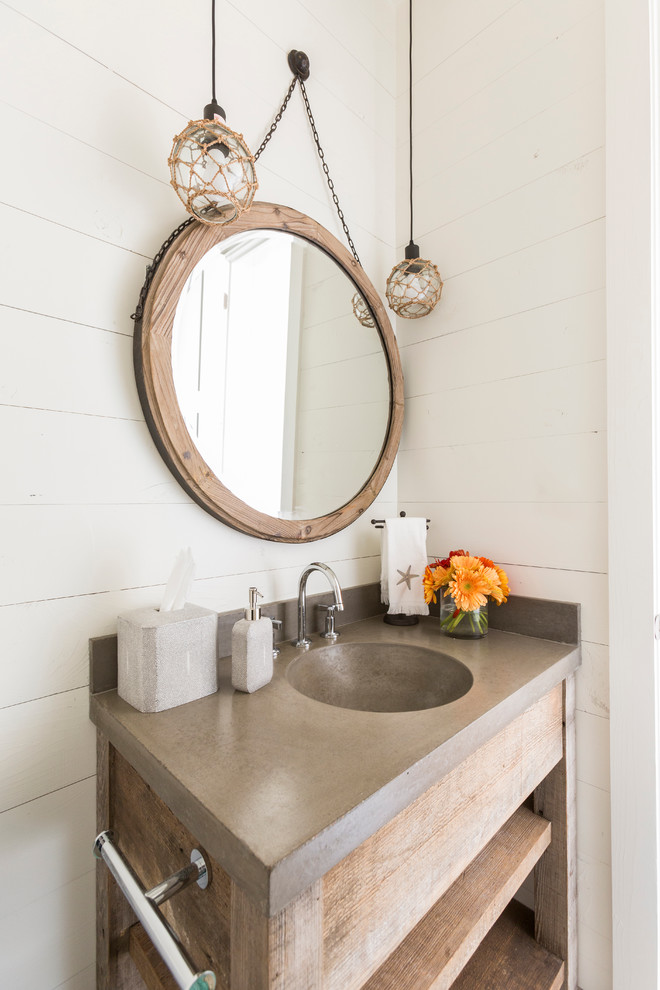 Cette image montre un WC et toilettes marin en bois clair avec un placard sans porte, un mur blanc, un lavabo intégré, un plan de toilette en bois et un plan de toilette gris.
