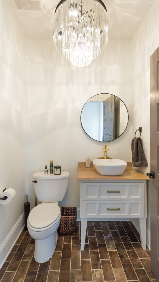 Photo of a small modern cloakroom in Atlanta with raised-panel cabinets, white cabinets, brown tiles, beige walls, ceramic flooring, a vessel sink and wooden worktops.
