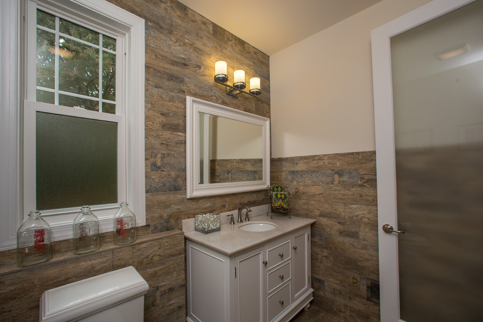 ワシントンD.C.にある高級な中くらいなトラディショナルスタイルのおしゃれなトイレ・洗面所 (アンダーカウンター洗面器、家具調キャビネット、白いキャビネット、セラミックタイル、白い壁、御影石の洗面台) の写真