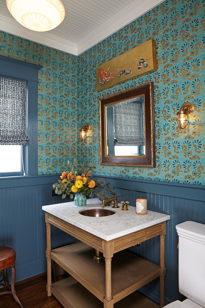 Idées déco pour un WC et toilettes classique en bois brun avec un lavabo encastré, un mur multicolore et parquet foncé.