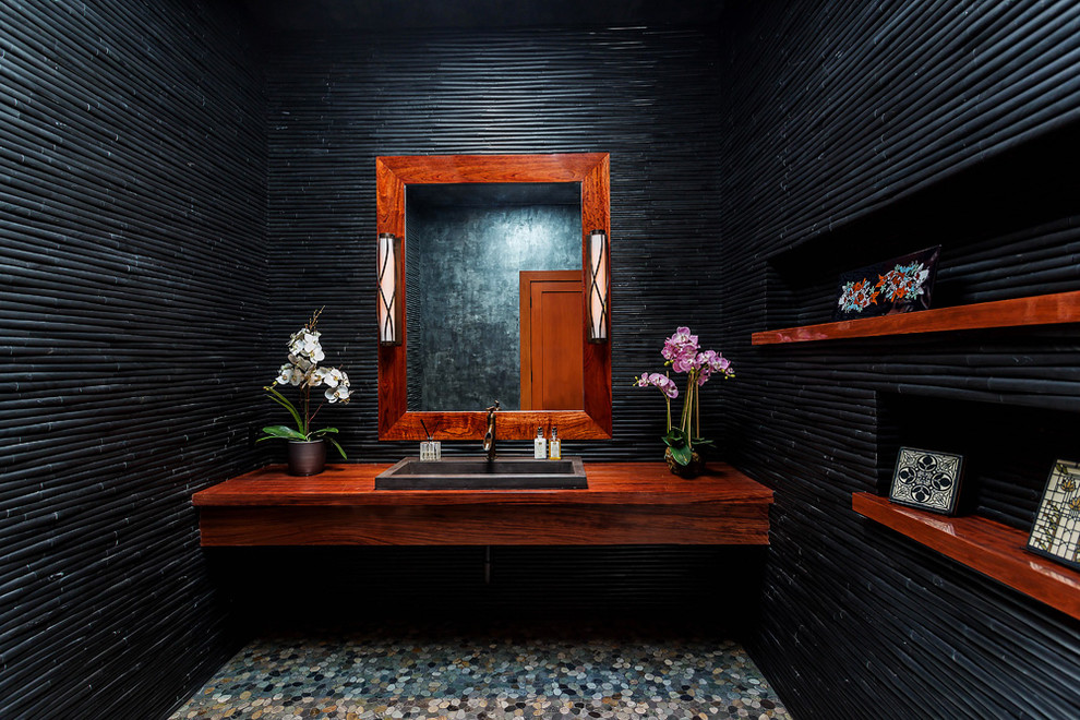 Inspiration för ett mellanstort amerikanskt brun brunt toalett, med svart kakel, svarta väggar, klinkergolv i småsten, ett nedsänkt handfat och grått golv