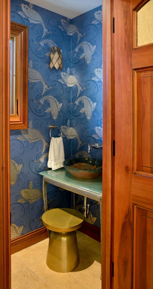 Example of a small tuscan blue tile limestone floor and beige floor powder room design in San Francisco with open cabinets, a two-piece toilet, blue walls, a vessel sink and glass countertops