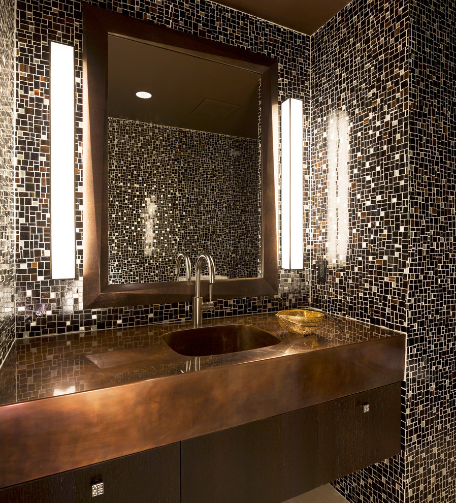 Moderne Gästetoilette mit integriertem Waschbecken, flächenbündigen Schrankfronten, dunklen Holzschränken, farbigen Fliesen, Mosaikfliesen und brauner Waschtischplatte in Sonstige