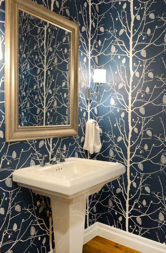 Imagen de aseo clásico renovado pequeño con paredes azules, suelo de madera en tonos medios y lavabo con pedestal