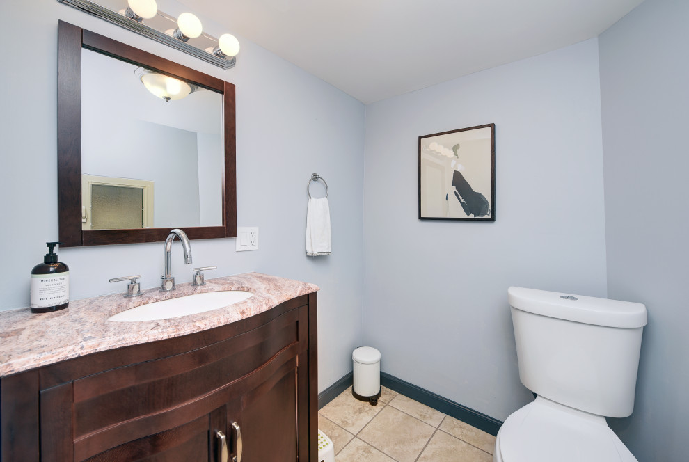 Design ideas for a small classic cloakroom in Other with recessed-panel cabinets, dark wood cabinets, a two-piece toilet, blue walls, porcelain flooring, a submerged sink, granite worktops, beige floors and beige worktops.